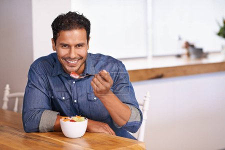 Photo for Portrait, smile and man eating fruit salad in home at table for healthy diet, nutrition or wellness at breakfast in the morning. Face, happy person and hungry for food, yogurt or organic strawberry. - Royalty Free Image