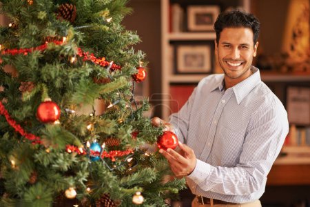 Photo for Happy man, portrait and Christmas tree with decor or bauble for festive, celebration or December at home. Male person with smile, ornament or interior decoration for traditional season or new year. - Royalty Free Image