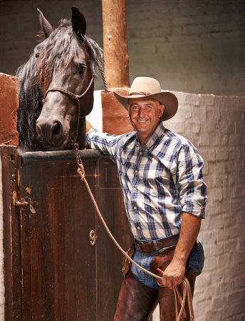 Téléchargez les photos : Cowboy, homme et cheval à la porte pour portrait avec soin, croissance et développement avec sourire, ranch et campagne. Personne, animal ou animal de compagnie avec amour, connexion et liaison pour le bien-être à l'écurie au Texas. - en image libre de droit
