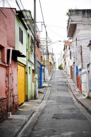 Téléchargez les photos : Maisons, barrio et rue en ville avec architecture, couleur et bidonville avec bâtiments sur route urbaine. Quartier, favela et appartement avec agrandissement, maison et ghetto à Sao Paulo. - en image libre de droit