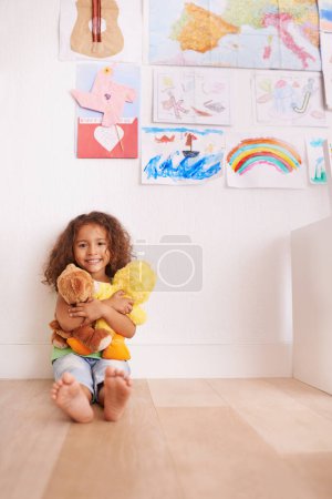 Foto de Retrato, sonrisa y niña abrazando osito de peluche en el dormitorio para mayor comodidad, amor y relax en casa. Felicidad, desarrollo infantil y cara de niño con peluche para jugar, abrazar y apoyar en casa. - Imagen libre de derechos