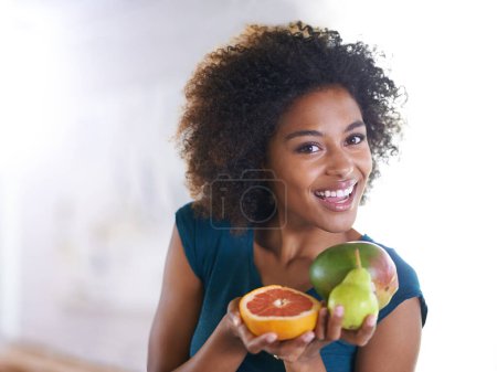Foto de Sonrisa, bienestar y retrato de mujer con fruta para merienda fresca, orgánica o nutricional para dieta. Feliz, salud y joven persona femenina con ingredientes de productos o comestibles en el apartamento moderno - Imagen libre de derechos