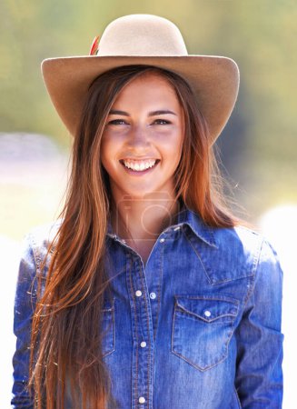 Foto de Vaquera, retrato y sombrero en granja, sonrisa y moda occidental para la agricultura, el trabajo y al aire libre en verano. Mujer, persona y agricultor en rancho para la sustentabilidad, el campo y el medio ambiente en Texas. - Imagen libre de derechos