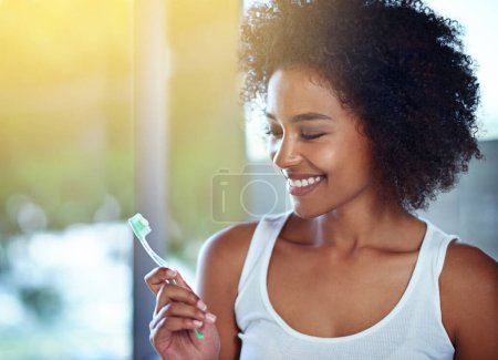 Foto de Mujer africana, cepillo de dientes y sonrisa en el baño para el bienestar oral, salud y beneficios para la boca en el hogar. Chica, persona y dientes blanqueamiento con producto, limpieza y pasta de dientes para los resultados en casa. - Imagen libre de derechos
