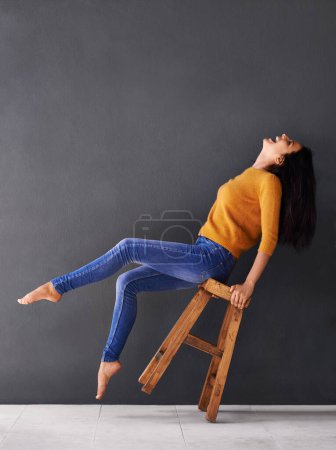 Photo for Woman, chair and fashion for style, trendy and laugh for smile and apparel in clothes and excited. Female person, excited and lean on stool for wardrobe, confident and elegant beauty and mockup. - Royalty Free Image