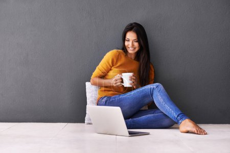Photo for Laptop, search and happy woman on a floor with coffee for streaming, reading or movie on wall background. Computer, mockup or female person online for google it, menu or Netflix and chill sign up. - Royalty Free Image