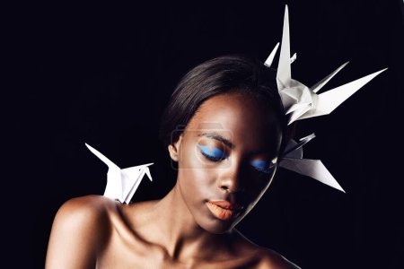Photo for Black woman, makeup and fine art with beauty, cosmetics or origami birds on a dark studio background. Closeup or face of African female person or model with dove or blue eye shadow on mockup space. - Royalty Free Image