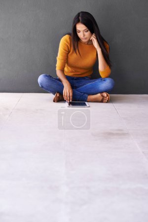 Photo for App, social media and internet for woman on floor with tablet for online, web and info on weekend. Blogger or content creator with finger on screen for engagement and tech for browse and relax. - Royalty Free Image