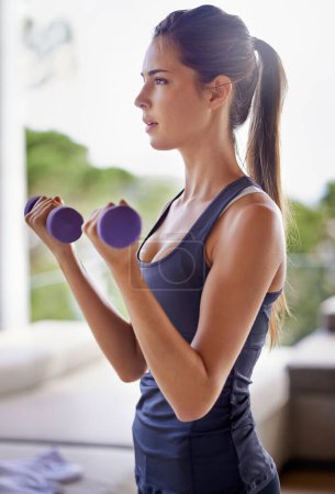 Photo for Gym, woman and dumbbells for fitness, wellness and training for workout indoors in house, home and apartment. Female person, athlete and strong with weights for exercise, health and vitality. - Royalty Free Image