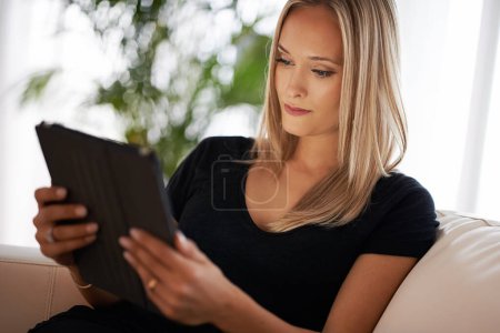 Photo for Calm, relax and woman with tablet on a sofa for social media, streaming or web, search or reading ebook at home. Digital, app and female person in a house with google it, sign up or Netflix and chill. - Royalty Free Image