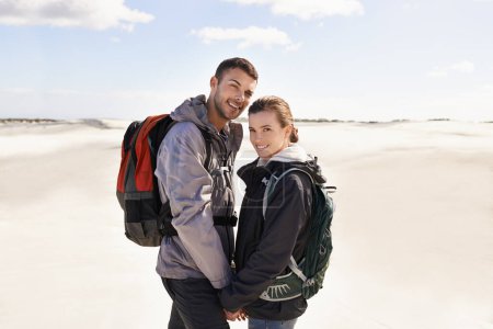 Photo for Hiking, sand dunes and couple in portrait for adventure, desert landscape and travel on holiday. Holding hands, explorers and happy nomad people in Sahara terrain, outdoor or dry climate for love. - Royalty Free Image