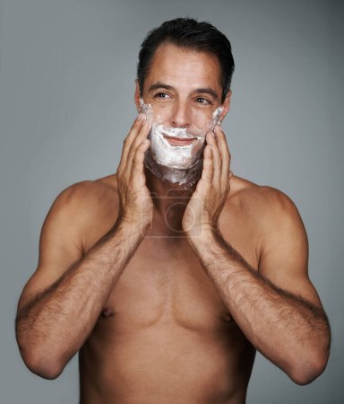 Photo for Man, shaving and foam for beard skincare or after shave with hair removal product, transformation or grey background. Male person, hands and studio wellness or face application, grooming or mockup. - Royalty Free Image