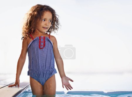 Photo for Kid, girl and water with face, swimwear and blue summer sky for relax and smile. Child, youth and sunshine with happiness, outdoor and play with curly hair and fun for sunny positivity and childhood. - Royalty Free Image