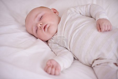 Photo for Baby, bed and sleeping in house for relax nap in pajamas for health development growth in nursery, wellbeing or morning. Kid, calm and comfortable youth in apartment for resting, family home or peace. - Royalty Free Image