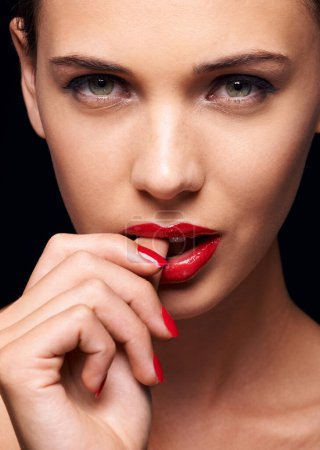 Photo for Beauty, makeup and portrait of woman for skincare in studio with manicure on hand isolated on a black background. Cosmetics, model and face of person with red lipstick on mouth, serious or bite thumb. - Royalty Free Image