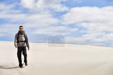 Photo for Travel, backpack or fitness man in desert for adventure, journey or resort, location and exploration. Freedom, holiday or male backpacker in Egypt for sand dunes walking, wellness or hiking in nature. - Royalty Free Image