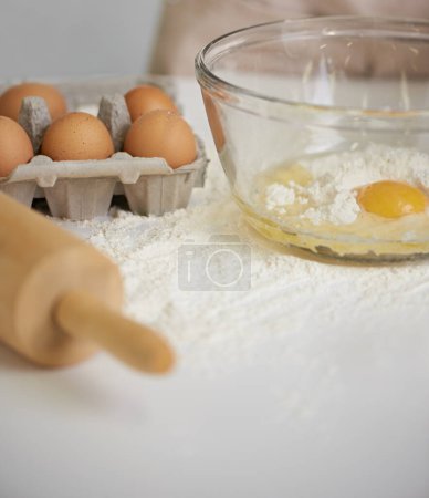 Photo for Baking, kitchen and eggs in bowl with flour for cake, bread and pastry preparation in home. Culinary, bakery and closeup of ingredients, wheat and utensils for pizza, dough and food on counter. - Royalty Free Image