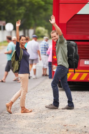 Photo for Couple, happy and wave for bus, travel and backpack for adventure, journey or transportation on street. Man, woman and smile outdoor in portrait with vehicle for road trip for vacation in Costa Rica. - Royalty Free Image