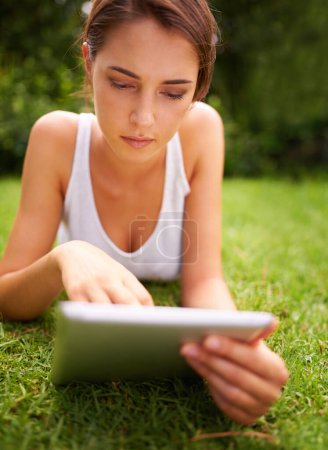 Photo for Tablet, online and woman relax in backyard or park for social media for chatting and texting on site of app. Peace, nature and female person in summer with ebook, connection and internet for reading. - Royalty Free Image