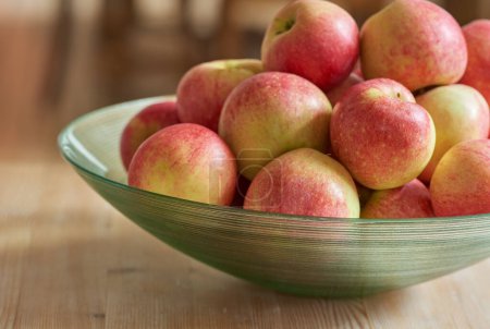 Téléchargez les photos : Fruits, cuisine et pommes rouges dans un bol sur la table pour la nutrition, l'alimentation et la nourriture pour le déjeuner à la maison. Naturel, été et sain pour manger le matin, petit déjeuner et frais avec de la vitamine C pour végétalien. - en image libre de droit