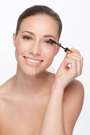 Photo for Mascara, portrait and woman with makeup for beauty, cosmetic product for lashes and volume on white background. Wand, eyelash care with smile and skin glow, change or transformation in studio. - Royalty Free Image