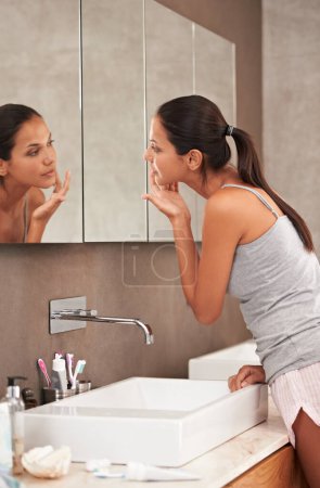 Photo for Bathroom, face in mirror and woman for skincare, beauty and wellness in morning routine. Health, dermatology and person in reflection for pimple, home or facial for cleaning, hygiene and grooming. - Royalty Free Image