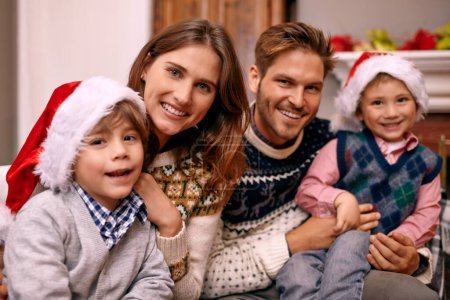 Téléchargez les photos : Noël, portrait et famille heureuse à la maison pour des vacances ou une célébration festive dans le salon. Noël, les parents et le visage des enfants avec des chapeaux dans le salon, les liens et les enfants ensemble à la fête dans la maison. - en image libre de droit