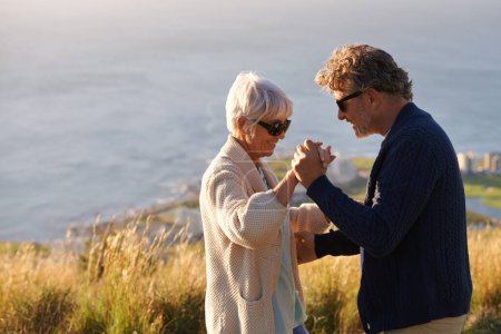 Photo for Happy, couple and dance outdoor on holiday, holding hands with love and relax on hill or mountain in Cape Town. Mature, people and embrace with kindness on vacation adventure in nature together. - Royalty Free Image