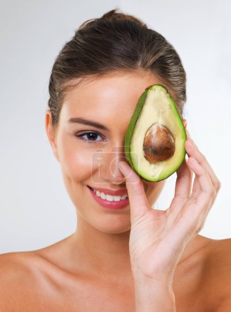 Photo for Woman, portrait and avocado for health in studio for wellness detox, healthy skin or hydration with smile. Model, person or fruit for organic cosmetics, natural beauty or skincare on white background. - Royalty Free Image