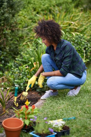Photo for Woman, gardening and fork for soil, plants and happy for spring, outdoor and sustainability. Girl, African person and smile on ground for growth, development and nature with ecology in backyard. - Royalty Free Image