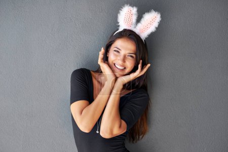 Photo for Bunny ears, happy or portrait of woman with fashion isolated on wall or grey background with style. Funny joke, confident lady or casual female person in studio with pride, smile and trendy clothes. - Royalty Free Image