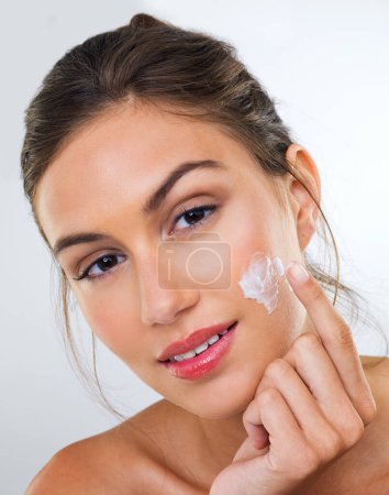 Photo for Woman, cream on face and skincare for beauty, dermatology with cosmetics product or moisturizer in studio. Portrait, skin wellness with sunscreen or lotion for glow and antiaging on white background. - Royalty Free Image