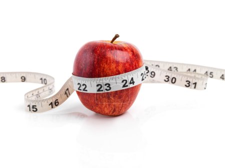 Photo for Apple, wellness and measuring tape with red fruit in studio isolated on white background for diet, health or nutrition. Sustainability, size and minerals with organic produce for detox or weightloss. - Royalty Free Image