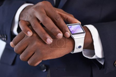 Businessman, hand and smart watch on wrist with display, online schedule and digital agenda for job. Black person, suit and technology with homescreen on arm for network, application and check time.