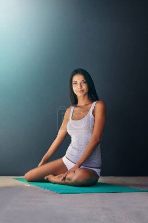 Téléchargez les photos : Tapis de yoga, santé et portrait de femme calme dans l'appartement pour zen, bien-être et exercice de fitness. Équilibre, sourire et jeune femme avec pilates séance d'entraînement pour le mouvement du corps sur le sol à la maison - en image libre de droit