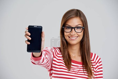Photo for Portrait, happy woman and showing phone screen in studio isolated on white background. Face, smartphone or person with display for advertising, marketing or mockup space for social media with glasses. - Royalty Free Image