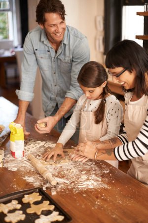 Photo for Parents, kid and happy with bake biscuits in kitchen for easter season or bonding, child development and growth. Home, family and flower or dough for cookies with fun, teaching and support on holiday. - Royalty Free Image