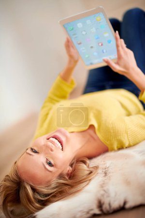 Foto de Retrato, tableta y sonrisa con la mujer en el piso de la casa para la navegación, la comunicación o el fin de semana libre. Tecnología, medios sociales y relajarse con los jóvenes felices en la sala de estar del apartamento. - Imagen libre de derechos
