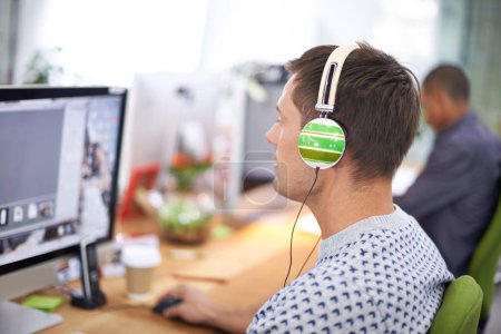 Photo for Business, designer and man with headphones at computer screen in office for creative internship and web design. Employee, rear view and monitor for multimedia production and video animation at desk. - Royalty Free Image