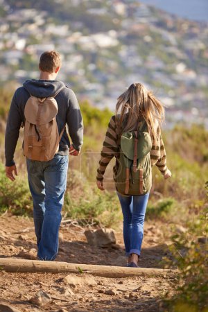 Photo for Vacation, hiking and couple walking in nature for holiday, travel or adventure outdoor with backpack. Rear view, man and woman trekking in the countryside on journey, date and exploration together. - Royalty Free Image
