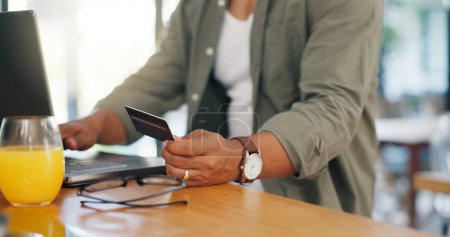 Photo for Man, credit card and laptop at desk for successful online shopping, gambling or subscription at home. Male person, technology and hands gesture for ecommerce, booking or payment for traveling. - Royalty Free Image