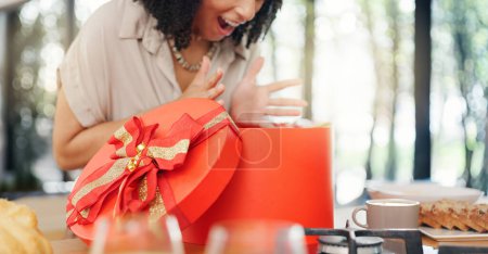 Photo for Woman, excited and open gift box in home with surprise, romance and love in marriage on valentines day. Lady, nervous and shake a red present for anniversary, care and gratitude by kitchen counter. - Royalty Free Image