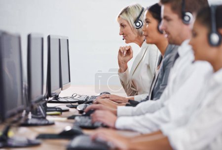 Photo for Help desk, phone call and row of women, men and typing on computer at customer support. Headset, telemarketing and client service agent at callcenter for online consultation, team and business people. - Royalty Free Image