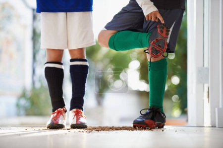 Photo for Soccer player, friends and cleats or sports athlete with dirt in home or competition game, workout or training. People, legs and fitness fit in house or football exercise as youth, cardio or practice. - Royalty Free Image