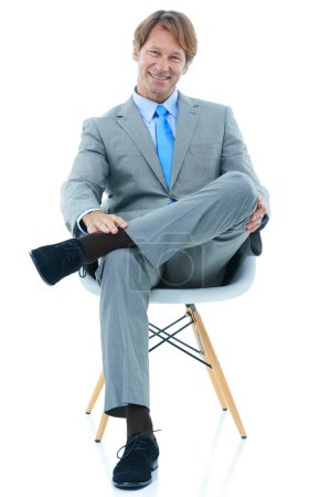 Foto de Feliz hombre de negocios, sentado y retrato de estudio con confianza en la carrera corporativa y profesional en traje. Empresario, sonrisa o cara en silla para satisfacción laboral o ambición por fondo blanco. - Imagen libre de derechos