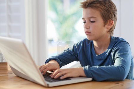 Photo for Home, boy and kid with laptop to search for online learning or education for child development and study. Internet, homework and research with information or notes for school assignment or project. - Royalty Free Image