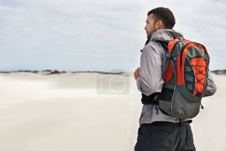 Photo for Hike, dunes and male person in nature for adventure, desert landscape and travel for holiday. Fitness, explorer and nomad man people in Sahara terrain, outdoor or workout in dry climate and scenery. - Royalty Free Image