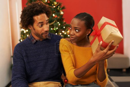 Photo for Surprise, present and black couple on Christmas with box or opening package on festive holiday or vacation. Excited, woman and man offer a gift in home with love, kindness and curiosity in marriage. - Royalty Free Image
