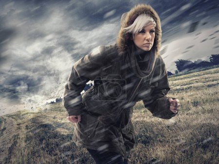 Photo for Woman, forest and running in storm weather, nature and survival or safety for climate change. Athlete, warm jacket or strong in woods with rain, environment or runner for global warming as warning. - Royalty Free Image