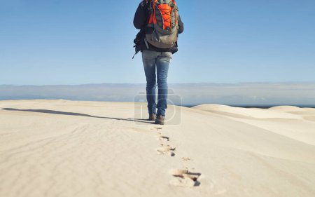 Photo for Walking, sand dunes or legs of person for adventure, desert landscape and travel for holiday vacation trip. Back view, hiker and nomad explorer hiking in Sahara terrain, outdoor and dry climate. - Royalty Free Image